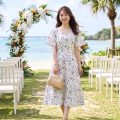 沖縄のビーチウエディング会場に立つ女性ゲスト