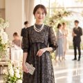 結婚式会場でパールを合わせた黒のレースドレスを着た女性